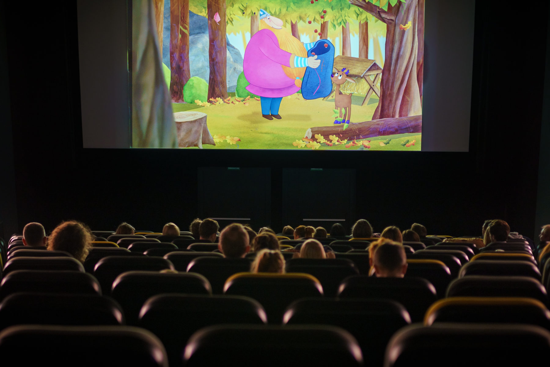 Kinowa sala, widok na ekran z kadrem bajki dla najmłodszych widzów.