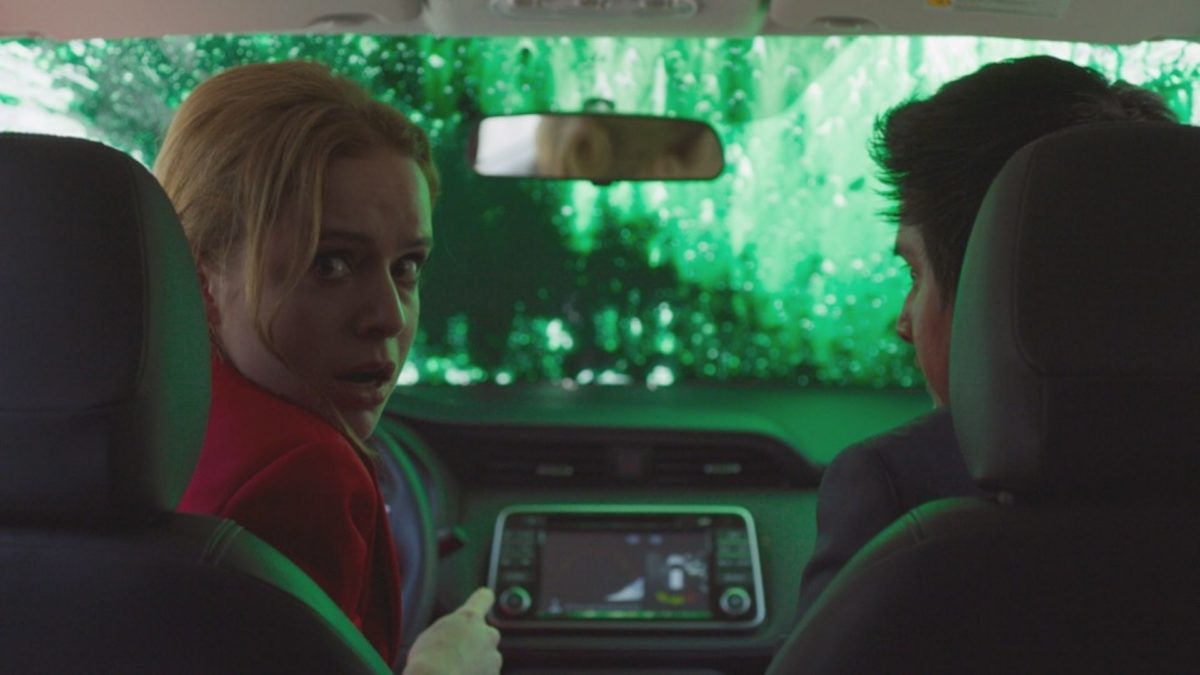 Para w samochodzie, kobieta prowadząca samochód ogląda się za siebie.