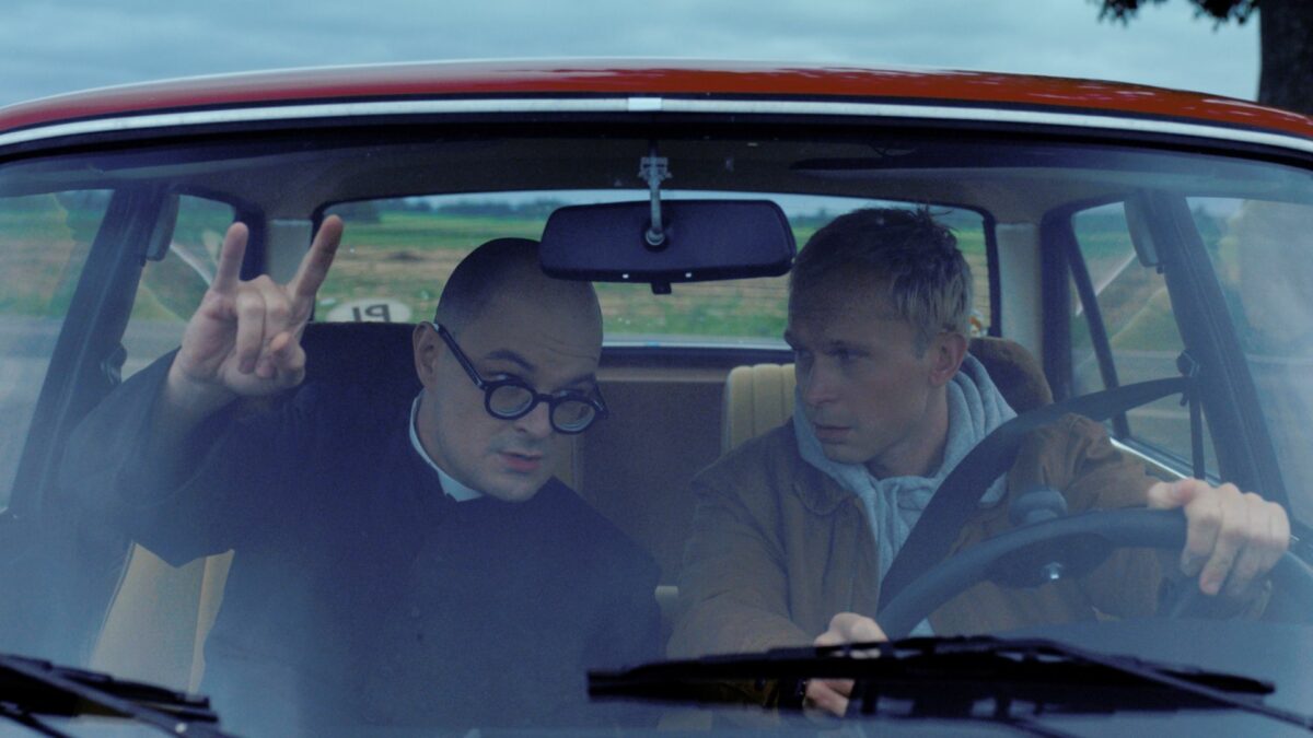 Dwójka głównych bohaterów w samochodzie na przednich miejscach.