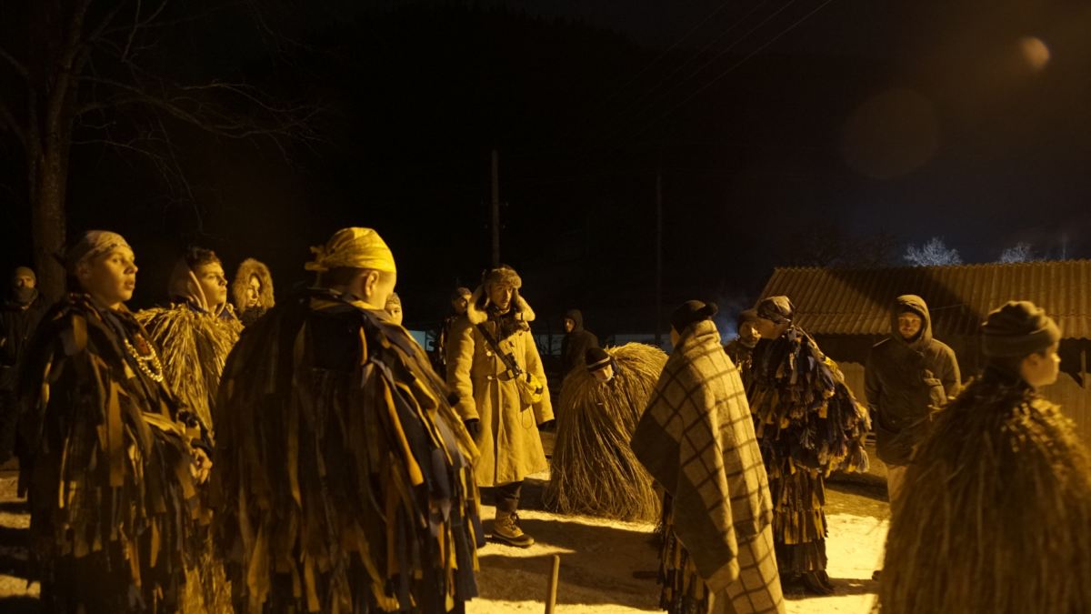 Staro ukraiński obrzęd, mężczyzna przebrany w pradawny strój, dookoła niego inni mężczyźni.