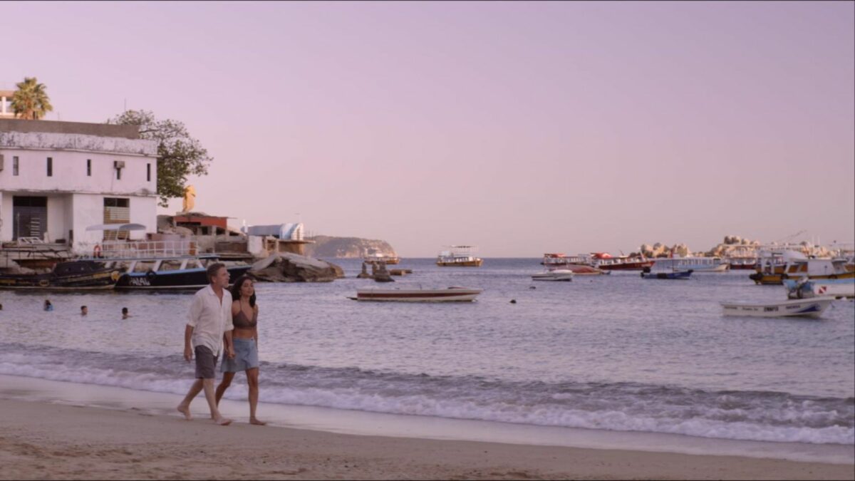 Para spacerująca na plaży o zachodzie słońca.