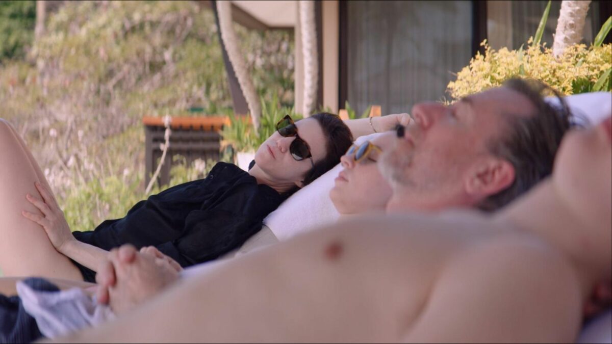 Rodzina odpoczywającą na leżakach przy basenie.