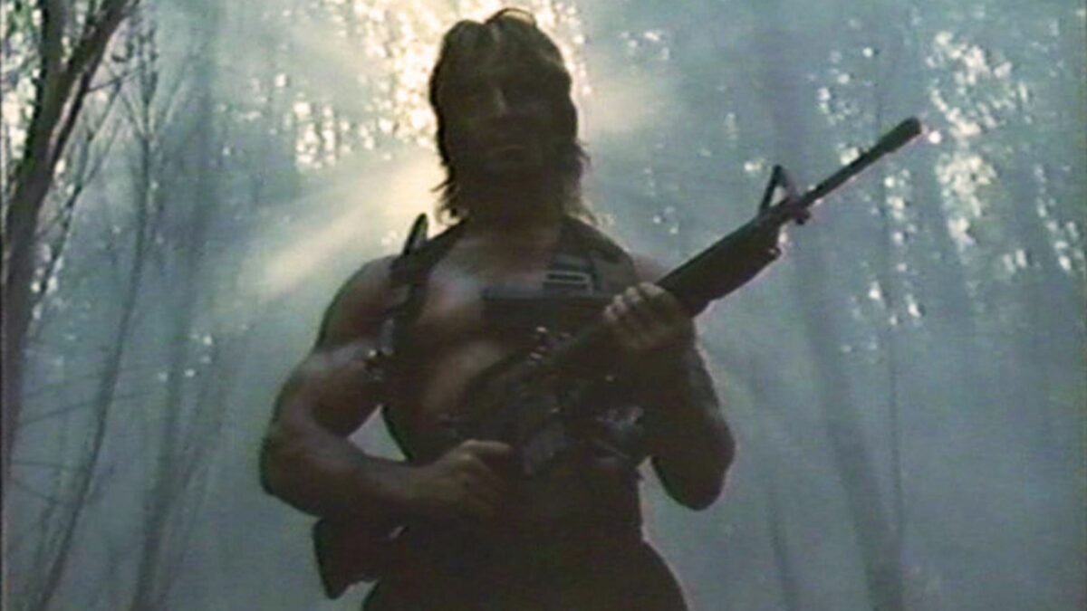 Mężczyzna w lesie z karabinem.