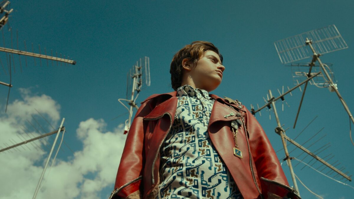 Spojrzenie na młodą dziewczynę z dolnej perspektywy na tle nieba i anten satelitarnych.