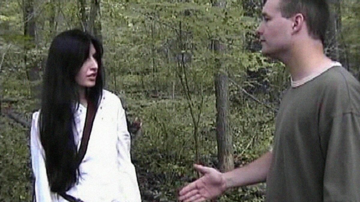 Kobieta i mężczyzna rozmawiający w lesie.