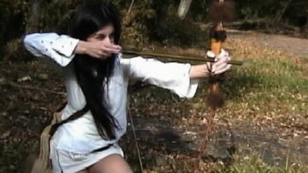 Młoda kobieta strzelająca z łuku.