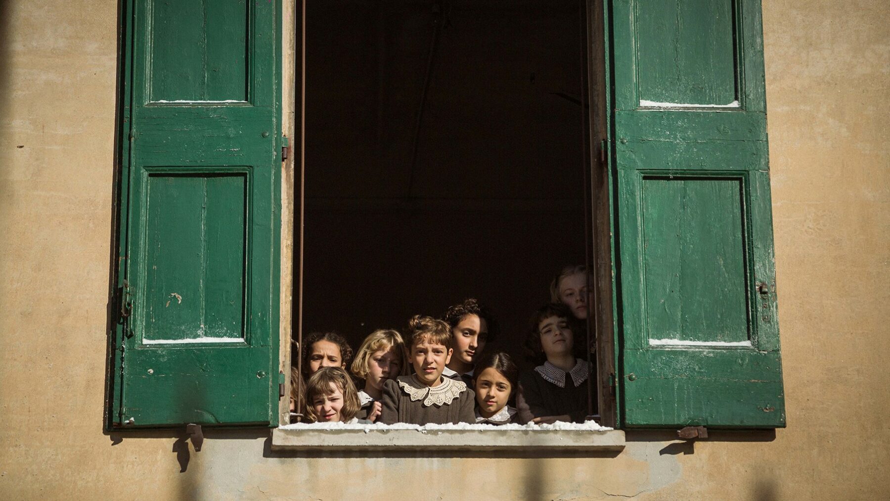 Grupa dzieci wyglądających przez okno.