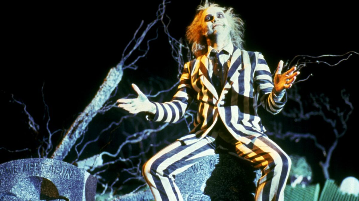 Beetle Juice siedzący na nagrobku.