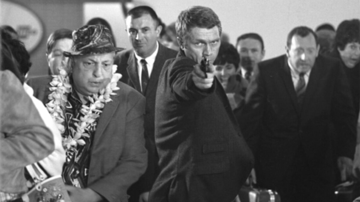 Mężczyzna w tłumie celujący z broni.