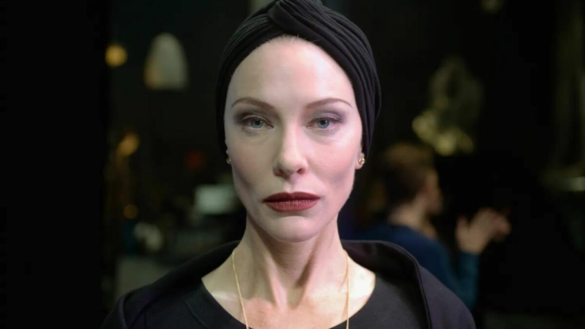 Kobieta w czarnym stroju oraz czarnym turbanie.