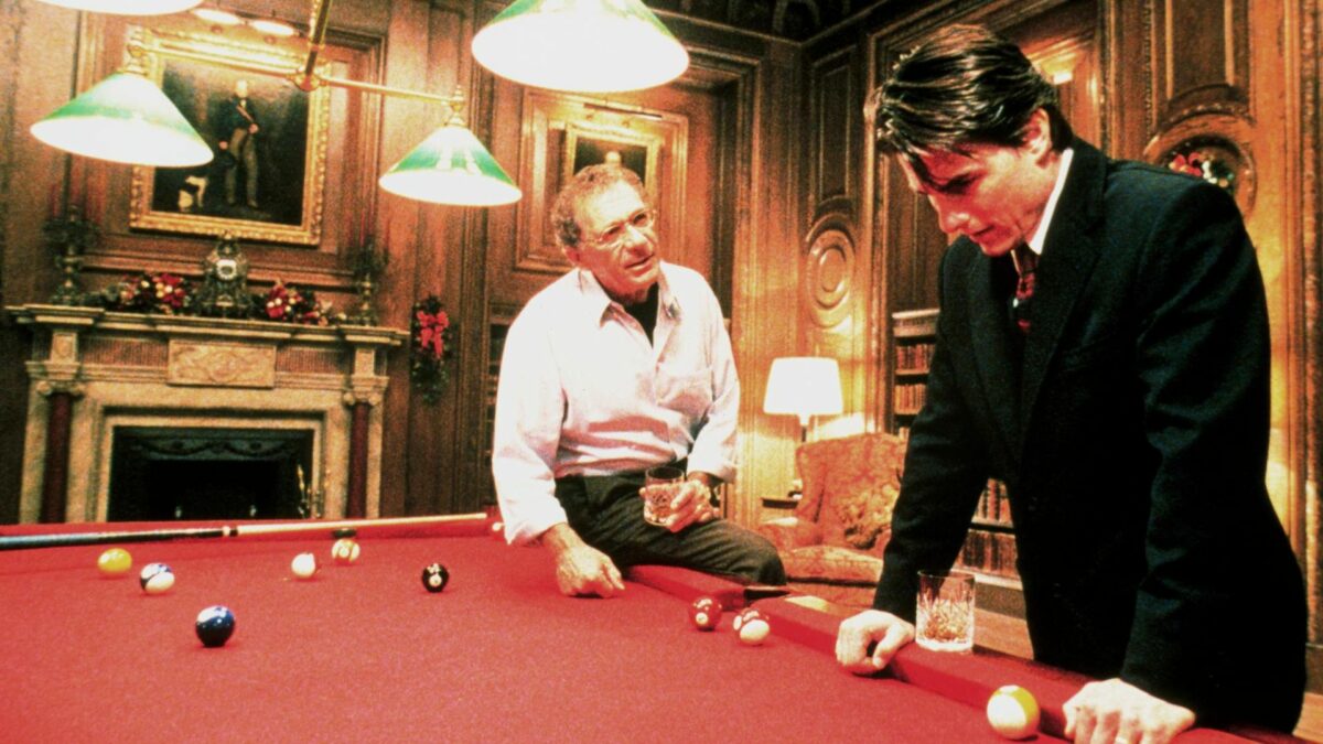 Kadr na scenę przy stole bilardowym, dwóch mężczyzn prowadzi rozmowę.