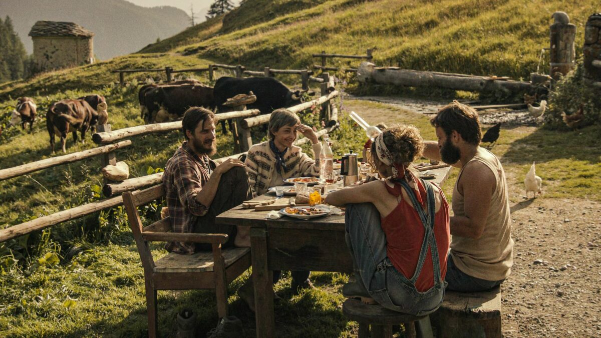 Grupa przyjaciół przy stole z jedzeniem.