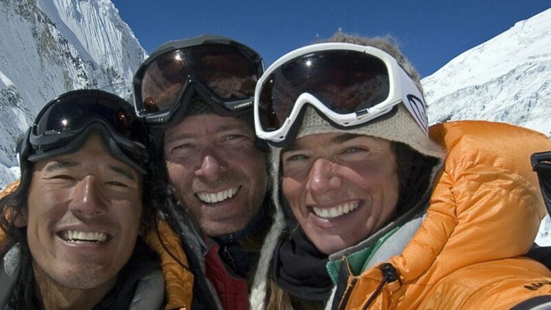 kobieta z dwoma mężczyznami robią sobie zdjęcie na zdobytym szczycie.