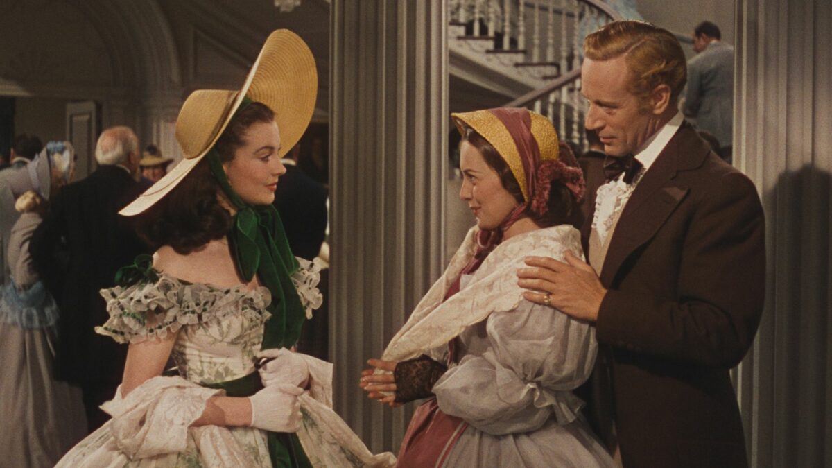 Dziewczyna wita parę gości w swoim domu.