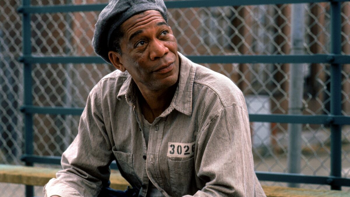 Zbliżenie na więźnia na tle krat.