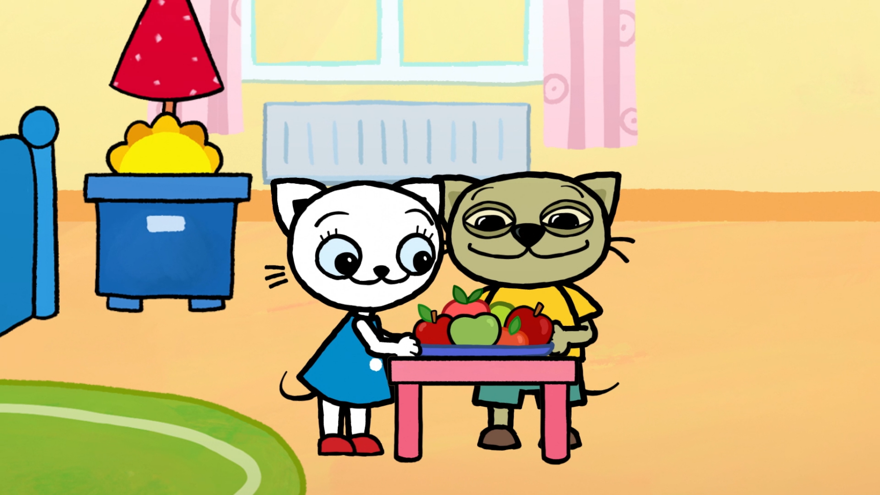 Kadr z bajki z dwoma kotkami przy stole pełnym owoców.