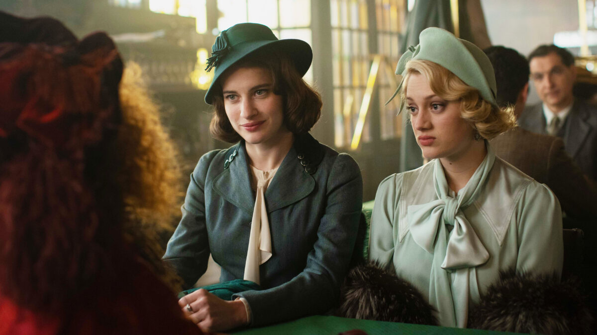 Trzy kobiety przy stoliku paryskiej kawiarni.