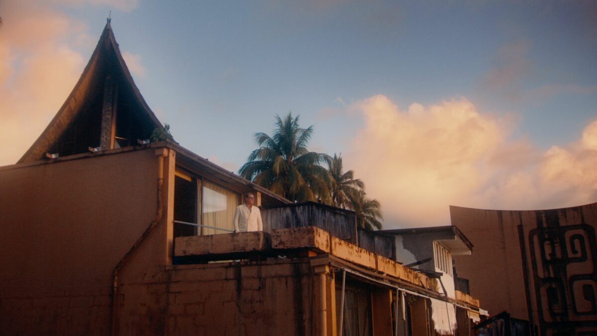 Kadr na wille z palmami, na tarasie bohater filmu.