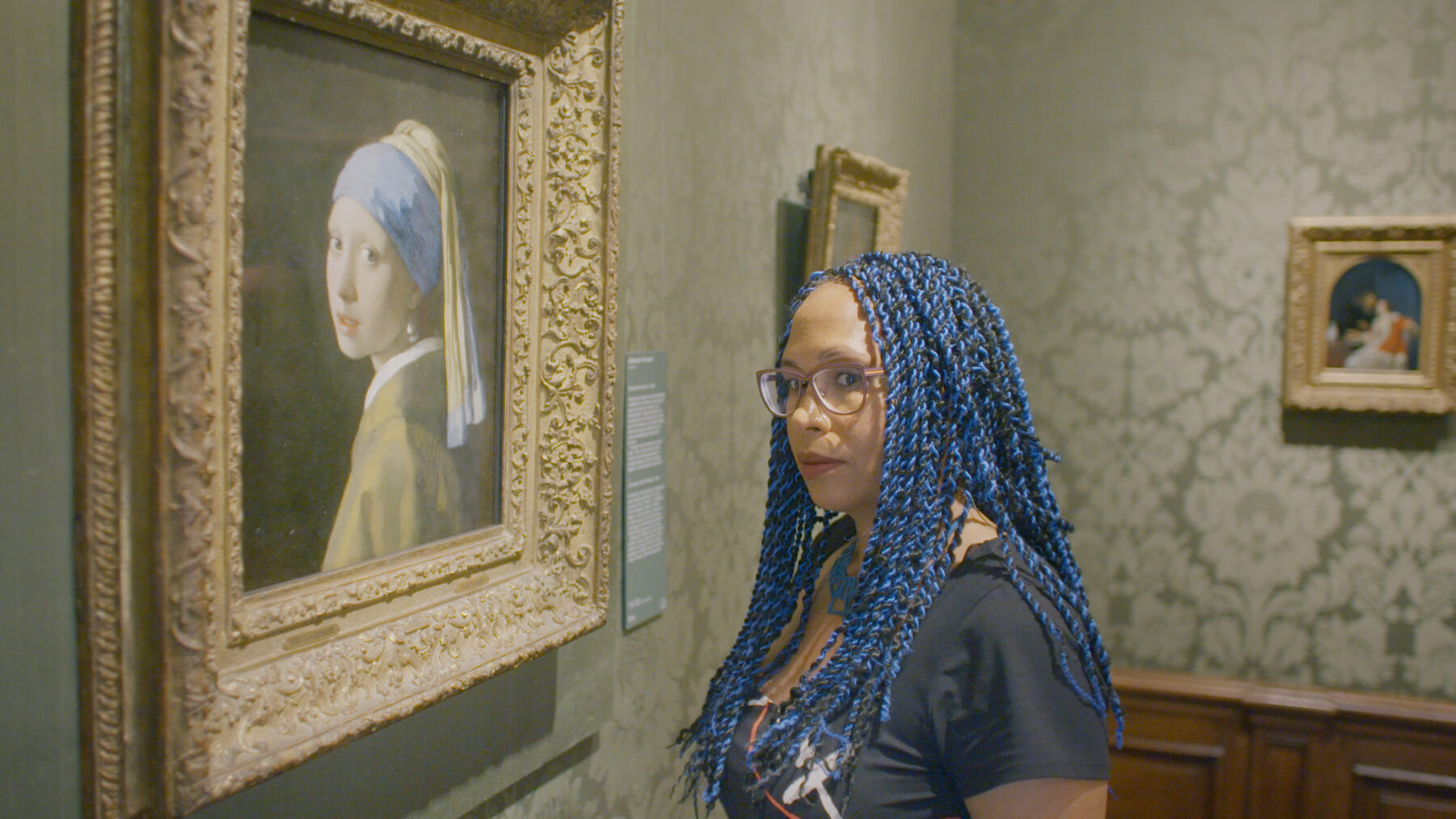 Kadr z muzeum, młoda kobieta oglądająca obraz Vermeera.