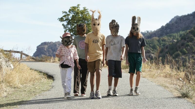 Piątka młodych ludzi w maskach na twarzy.