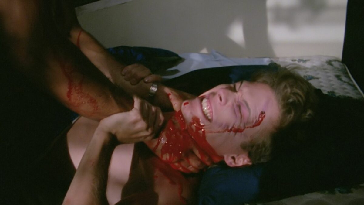 Kadr z walki dwóch mężczyzn, są zakrwawieni, jeden dusi drugiego.