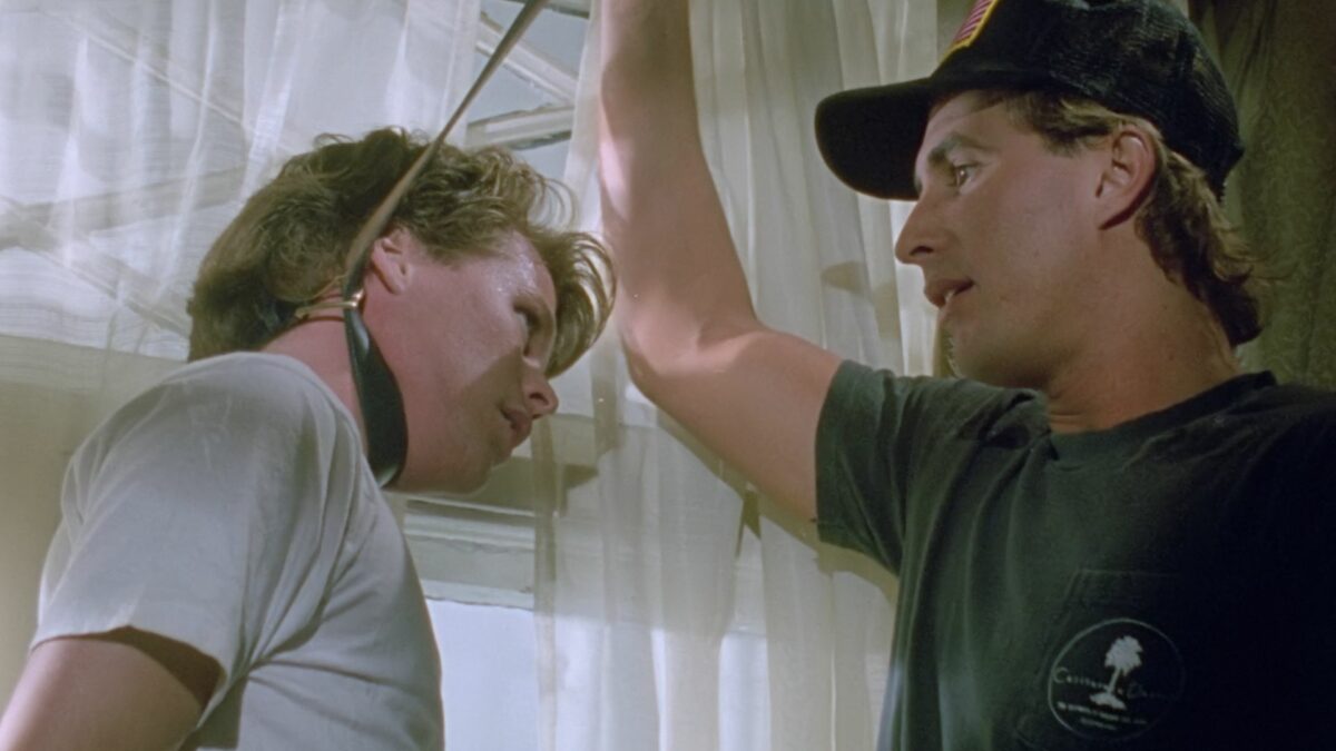 Mężczyzna zakłada pętle na szyje młodego chłopaka.