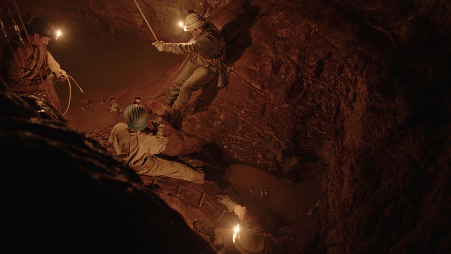 Kadr na trzech górników znajdujących się w podziemiach.