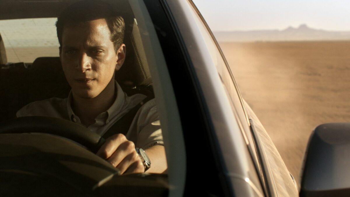 Mężczyzna prowadzący samochód na pustyni.