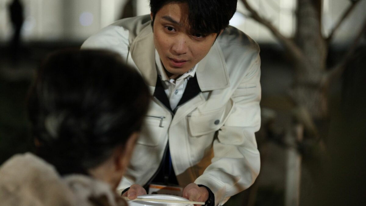 Młody chłopak z opieki zdrowotnej podaje posiłek starszej osobie.