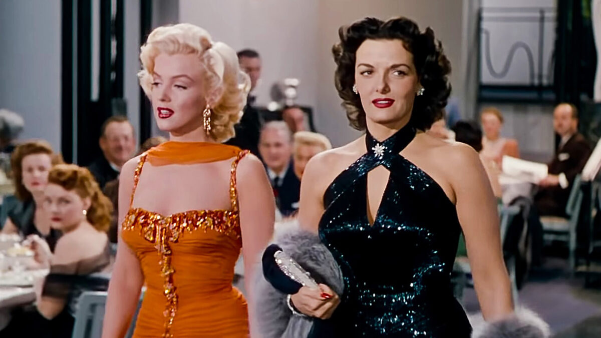 Dwie elegancko ubrane kobiety stoją pośrodku restauracji