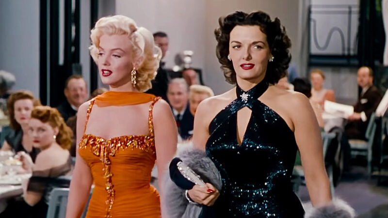 Dwie elegancko ubrane kobiety stoją pośrodku restauracji