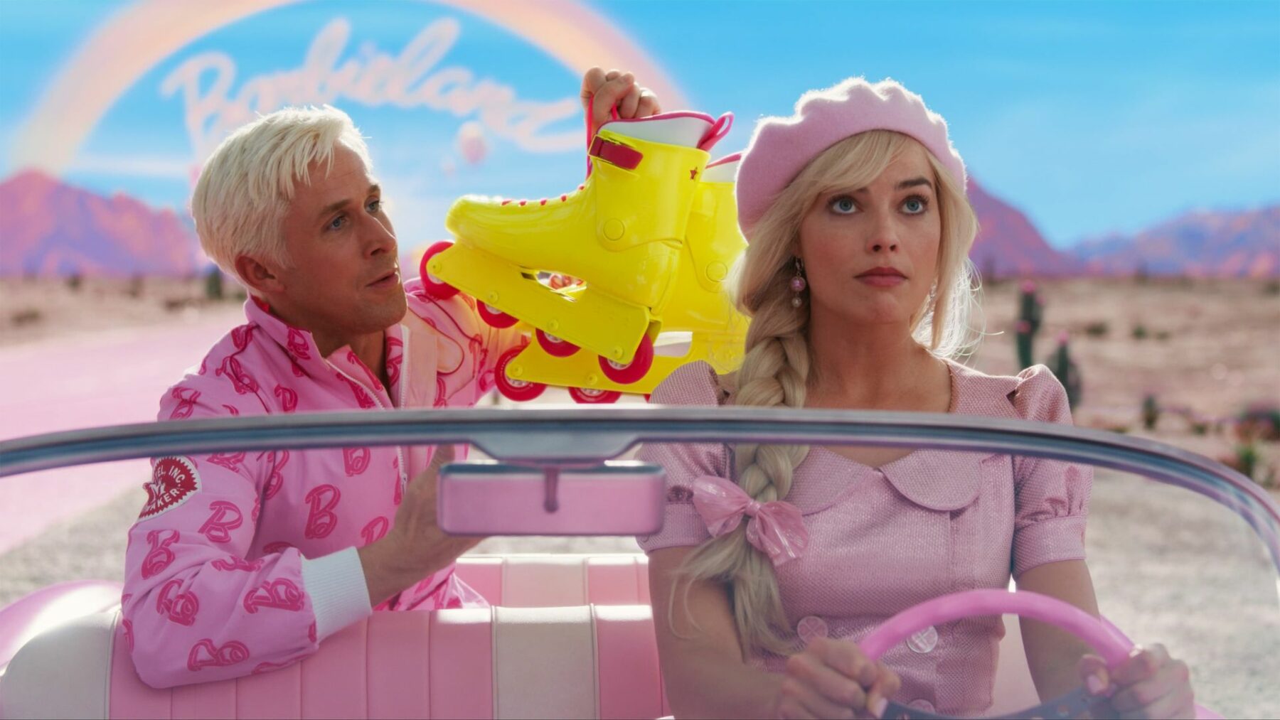 Ken i Barbie w różowym samochodzie, chłopak wręcza dziewczynie wrotki.