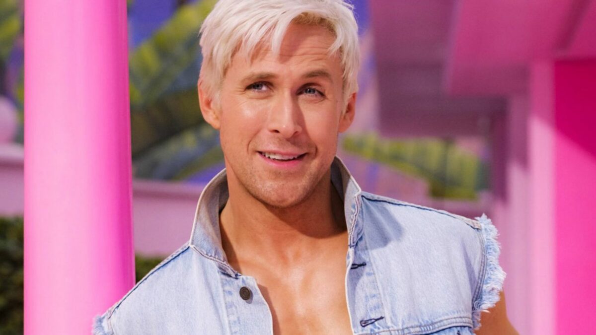 Zbliżenie na Kena, uśmiecha się, stoi na tle różowego domu.