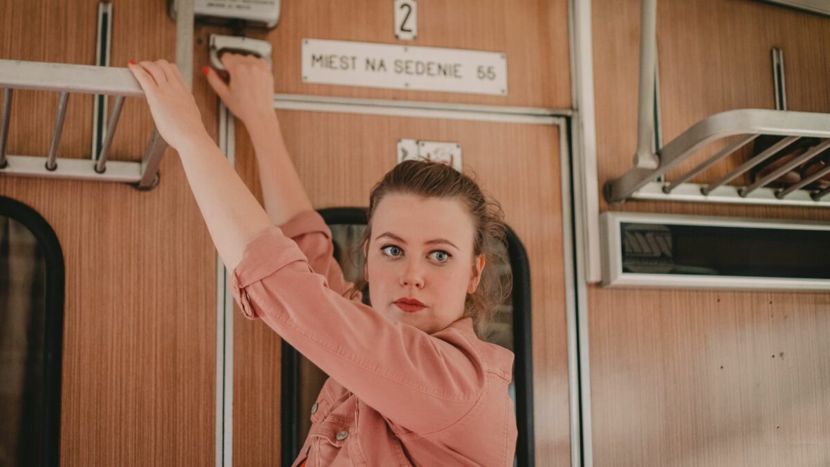 Młoda kobieta pociąga za uchwyt awaryjny w pociągu.