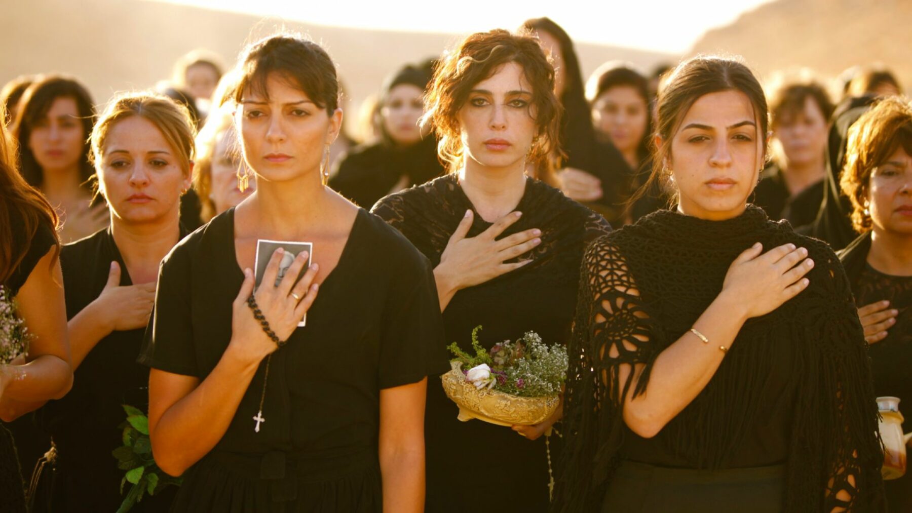 Grupa kobiet na uroczystości pogrzebowej.