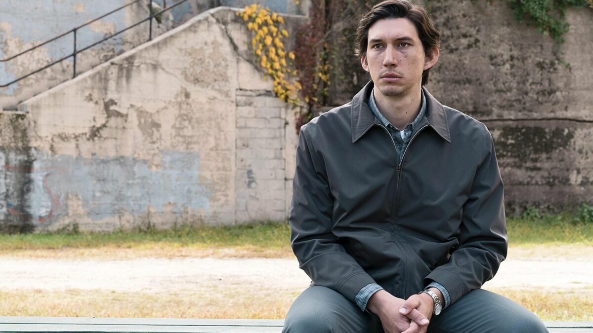 Mężczyzna siedzi na ławce w przestrzeni miejskiej.