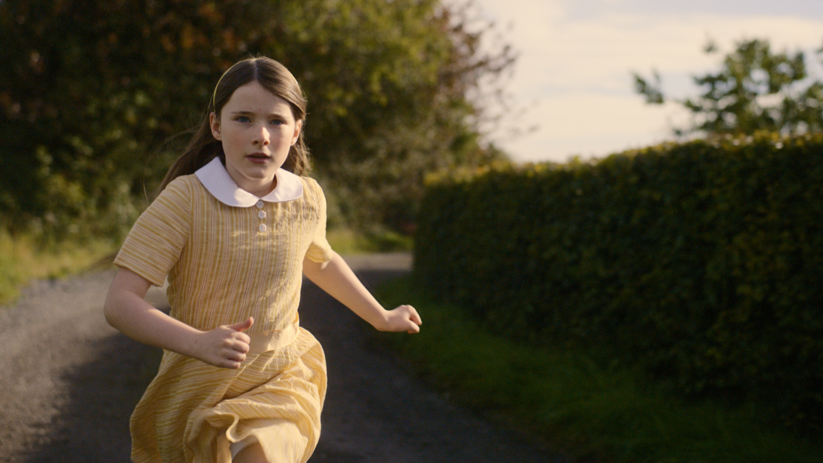 Biegnąca dziewczynka środkiem ulicy.