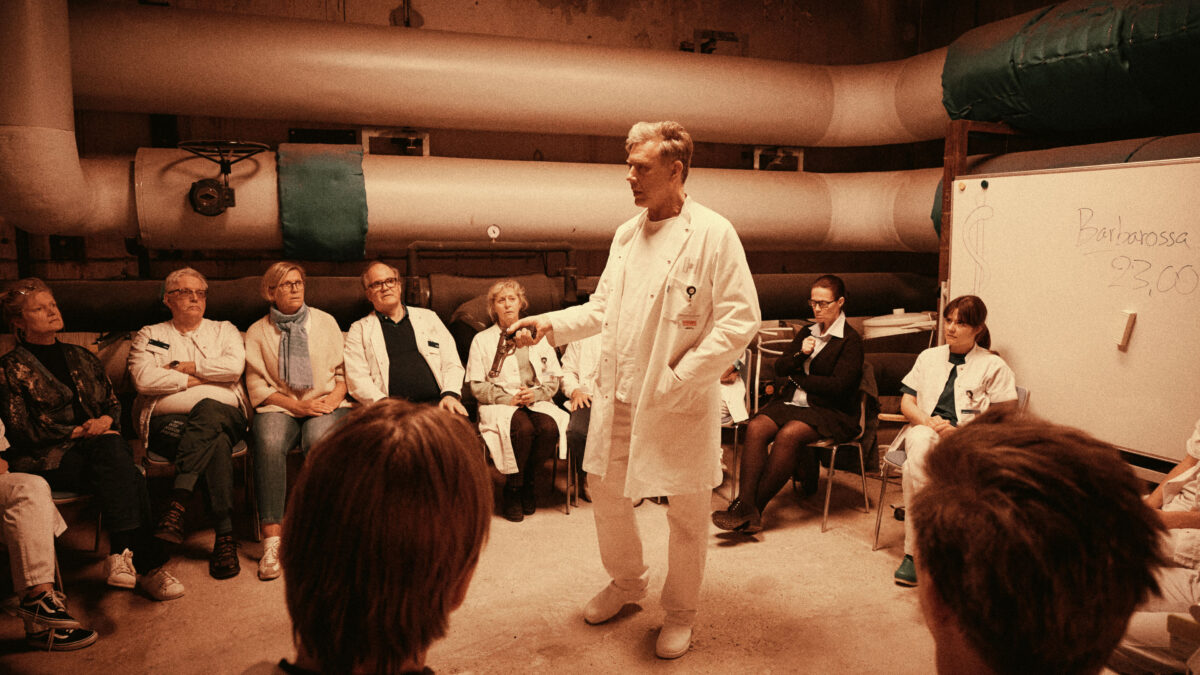 Doktor przemawiający do zebranych medyków.