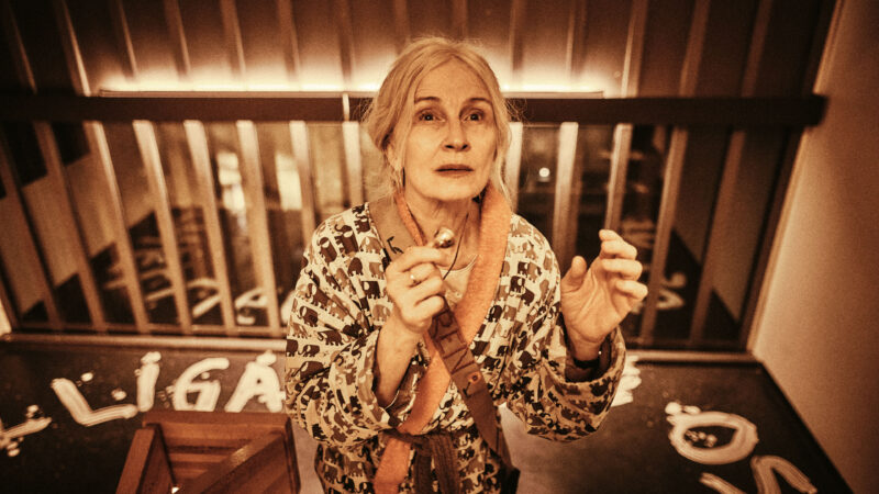 Obłąkana kobieta wchodząca po schodach klatki.