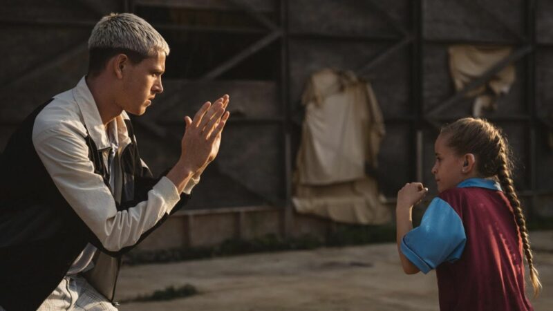 Młoda dziewczyna ćwiczy uderzenie bokserskie ze swoim kolegą.