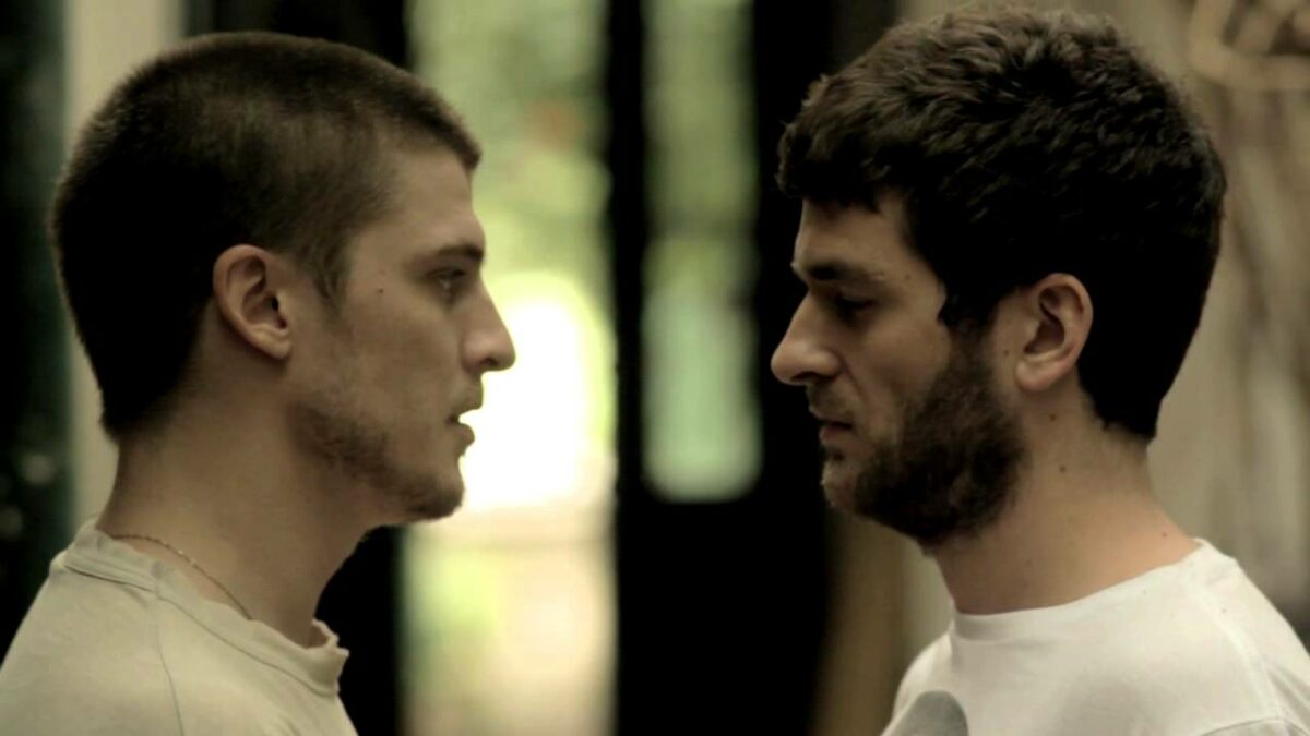 Dwóch chłopaków patrzy na siebie z naprzeciwka.