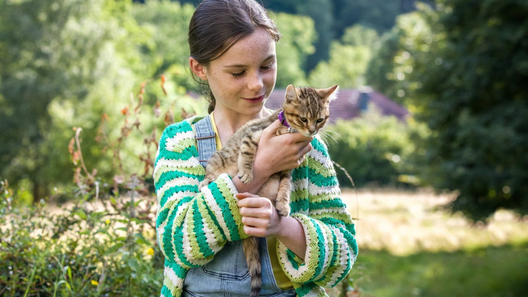 Dziewczynka trzymająca na rękach swojego małego kotka.