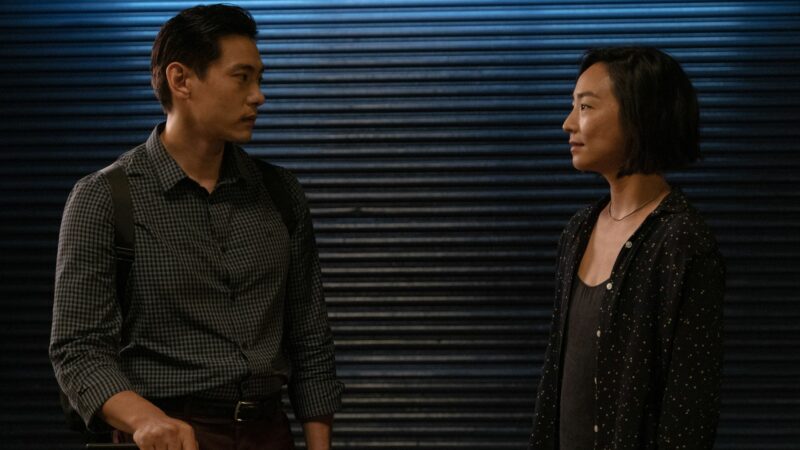 Rozmawiająca para na tle metalowych drzwi do garażu.