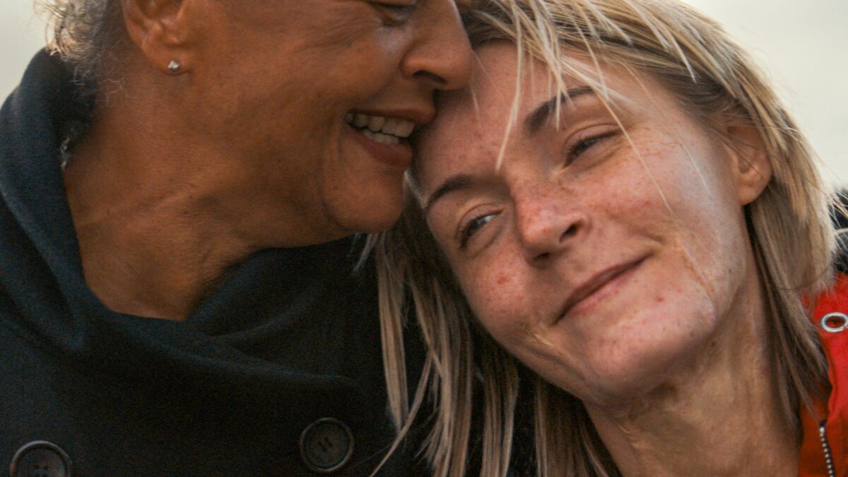 Kobieta przytulająca się do starszej kobiety.