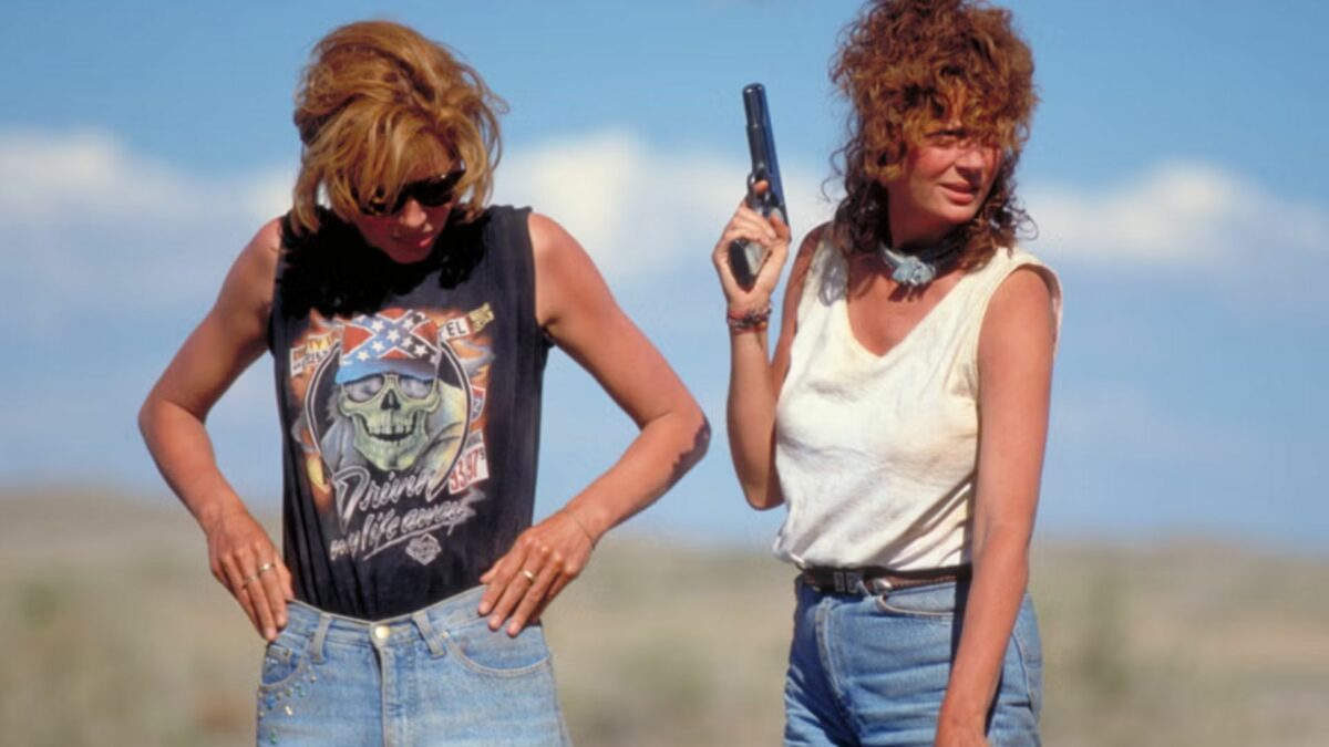Dwie bohaterki filmu na amerykańskich bezdrożach, jedna trzyma broń w ręku.