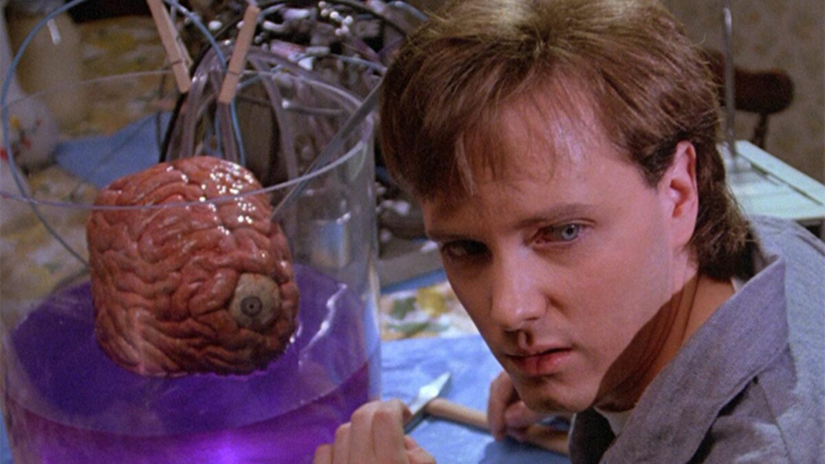 Mężczyzna w laboratorium, za nim słój z mózgiem.