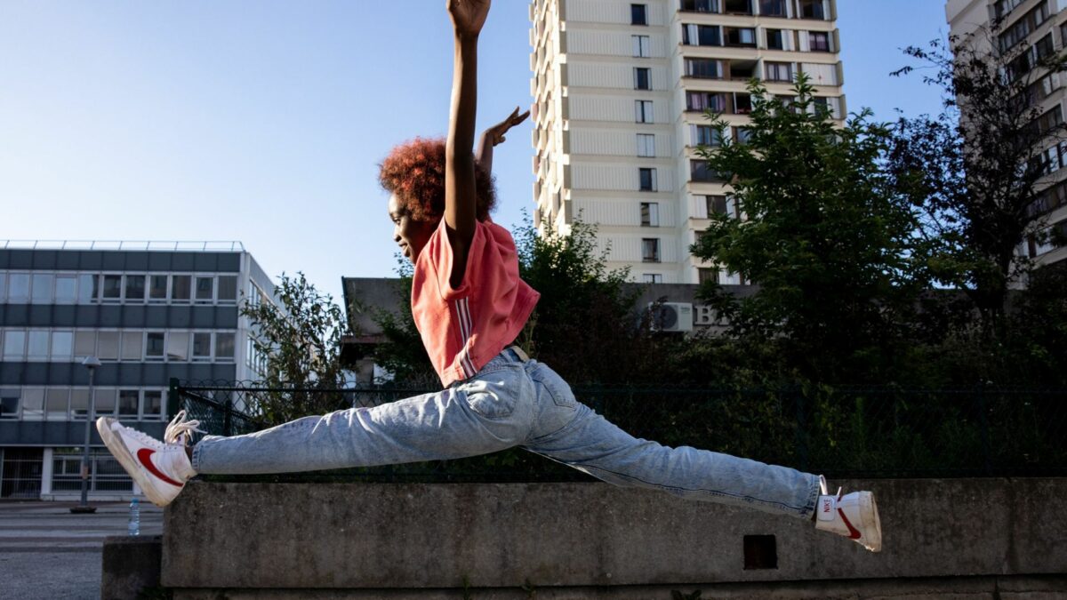 Młoda dziewczyna ćwiczy taniec w miejskim parku.