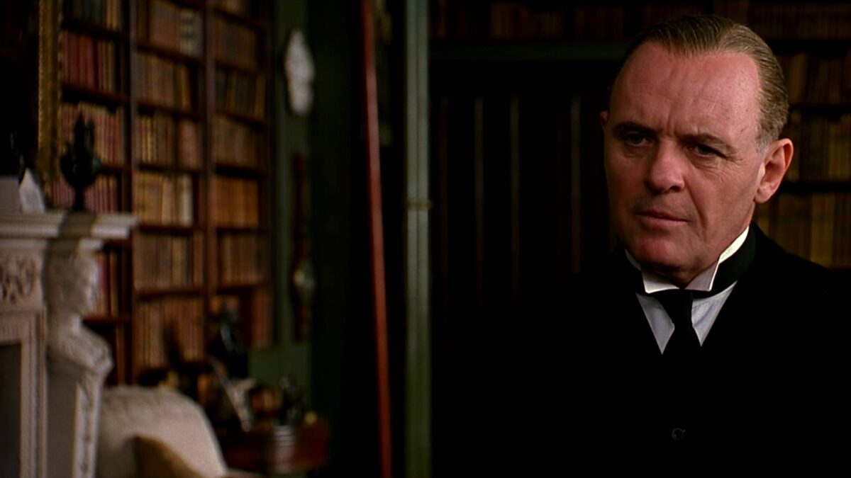 Starszy mężczyzna przy biblioteczce.