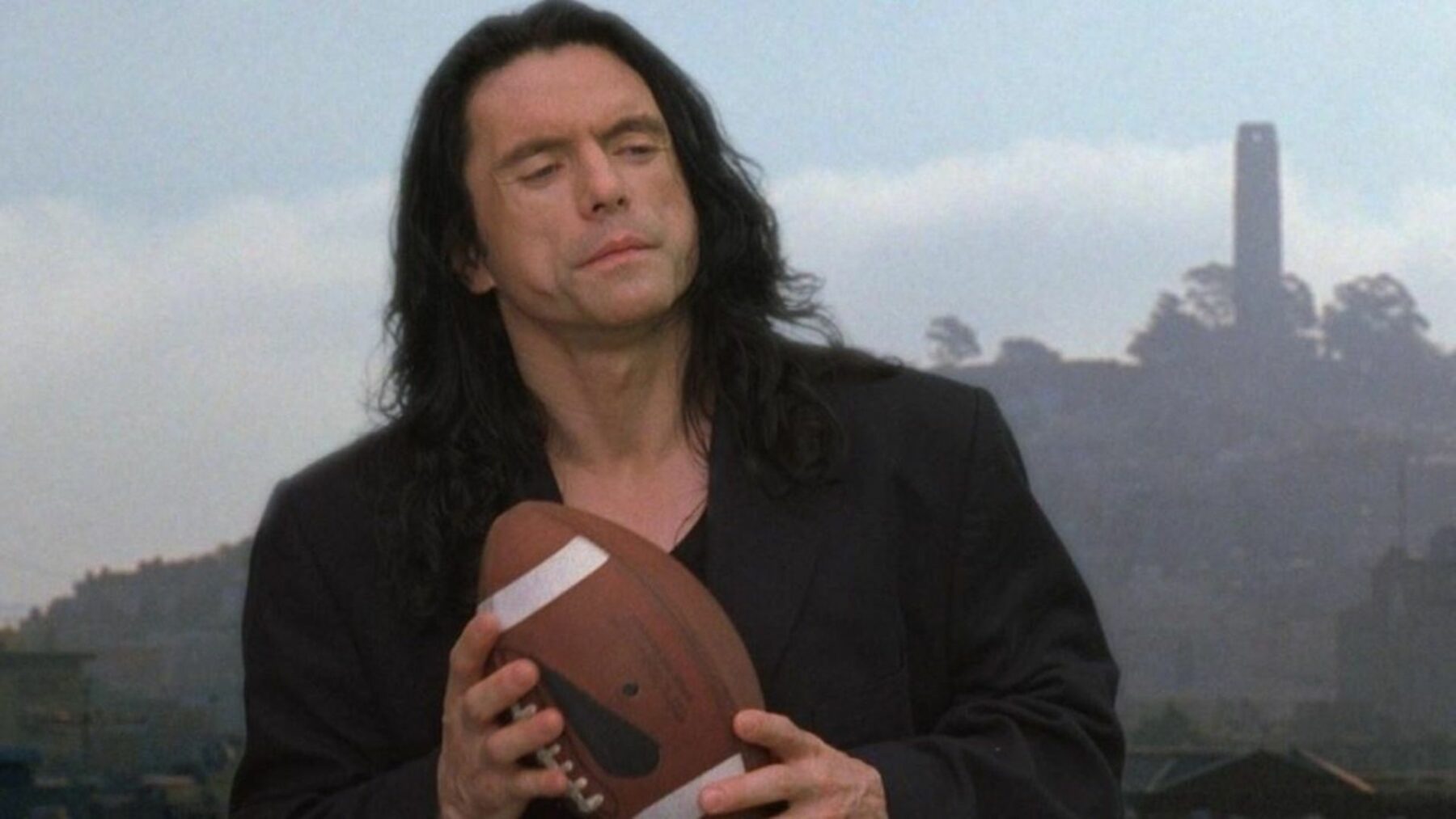 Główny bohater filmu trzymający piłkę do amerykańskiego footballu.
