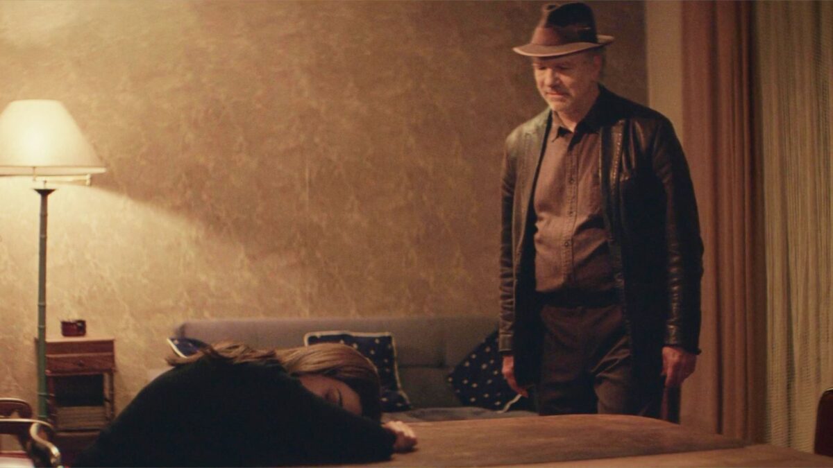 Mężczyzna przeglądający się dziewczynie, która zasnęła przy stole.